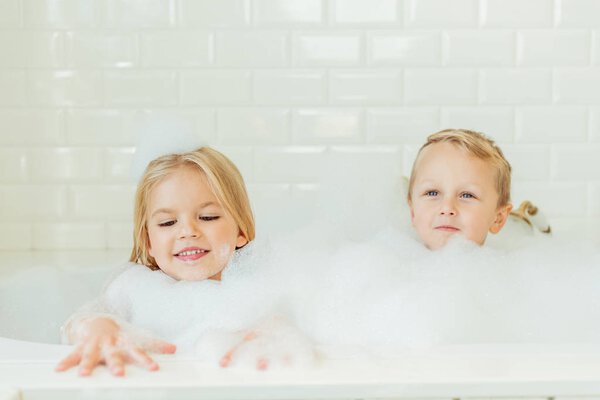 дети играют в ванне с пеной
