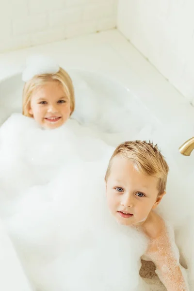 Enfants jouant dans la baignoire avec de la mousse — Photo