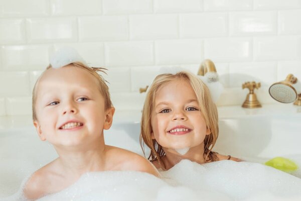 kids playing in bathtub with foam