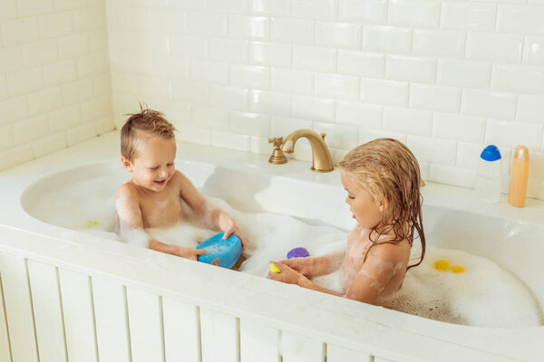 kids playing in bathtub with foam