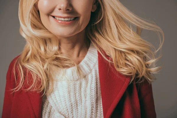 Улыбающаяся женщина в красном пальто — стоковое фото