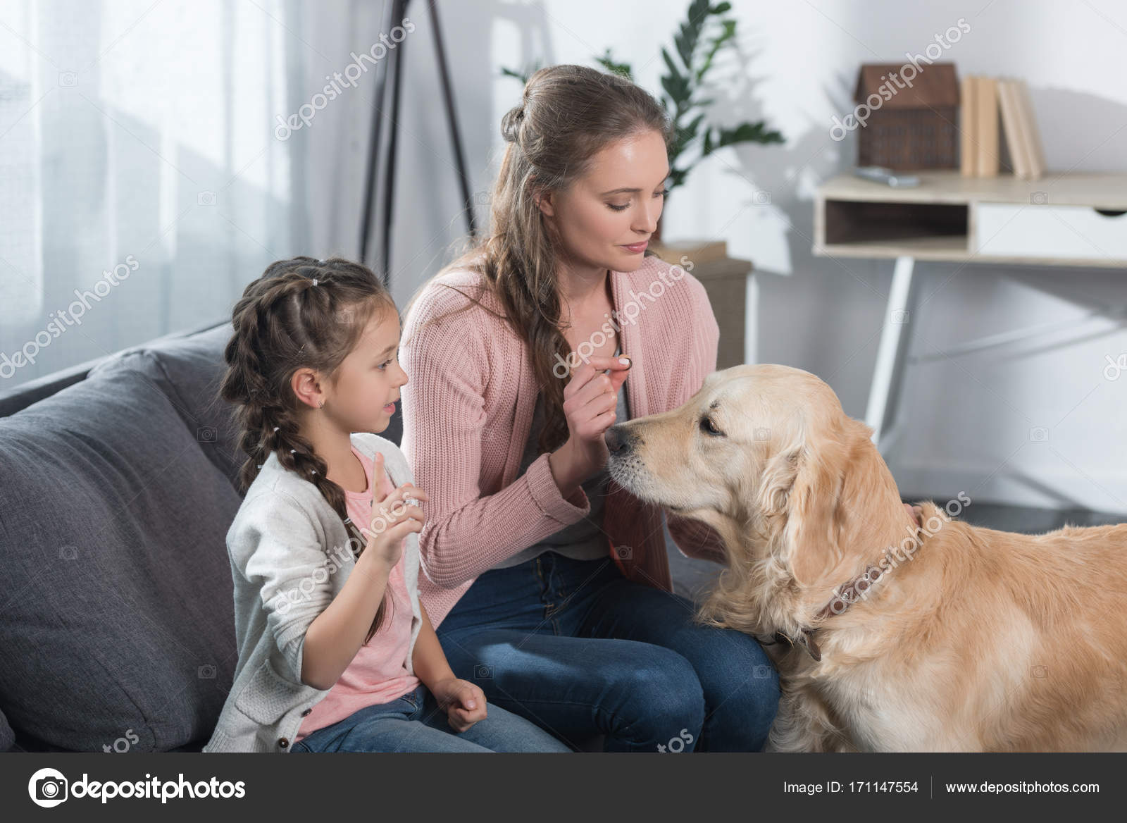 Mother and daughter petting dog — Stock Photo © AllaSerebrina 171147554