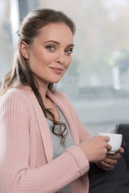 Bir fincan kahve tutan kadın.