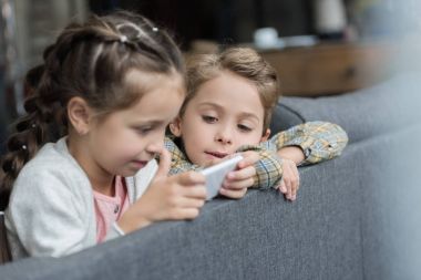 çocuklar kanepede smartphone kullanarak