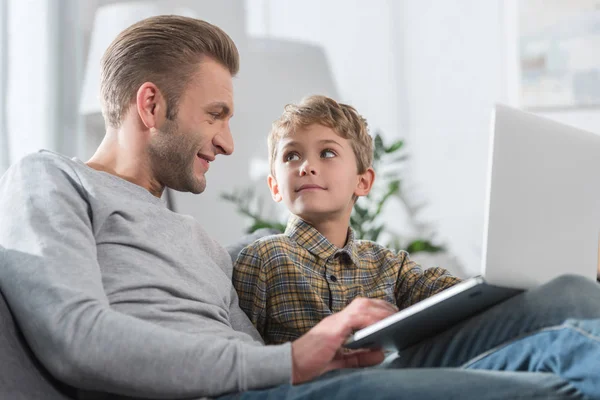 Отец и сын смотрят на ноутбук — стоковое фото