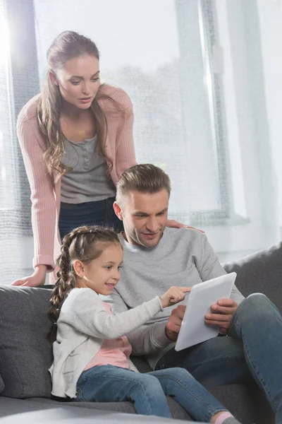 Familia sentada y mirando la tableta — Foto de Stock