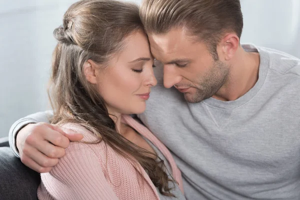 Couple going to kiss while sitting on sofa — Free Stock Photo