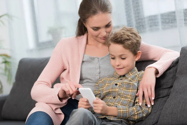 Matka pokazuje coś na smartphone — Zdjęcie stockowe