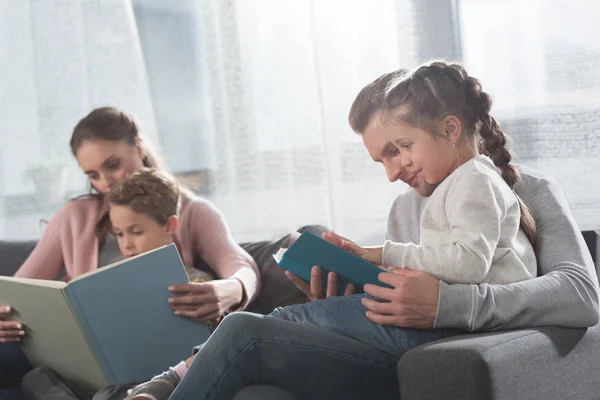 Padres enseñando a los niños a leer en casa —  Fotos de Stock