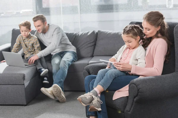 Famille avec enfants utilisant des gadgets sur le canapé — Photo