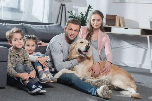 Familie og hund som sitter på gulvet – stockfoto