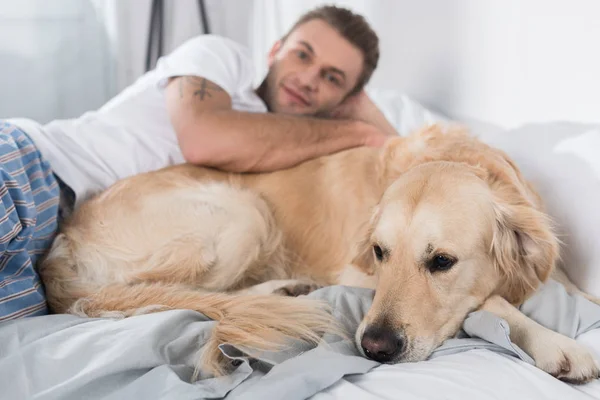 Man med hund i sängen — Stockfoto