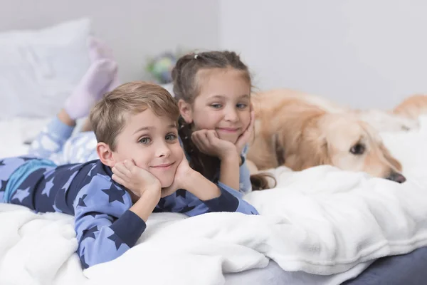 Τα παιδιά στο κρεβάτι με το σκύλο — Φωτογραφία Αρχείου