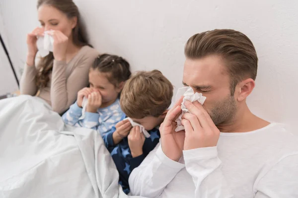 Familia soplando narices en servilletas — Foto de Stock