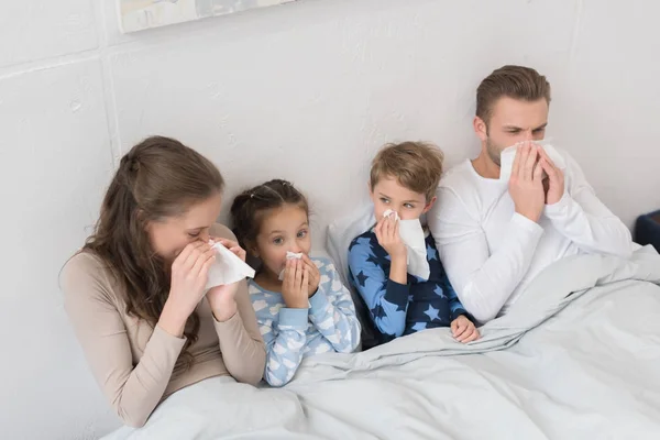 Familj blåser näsor i servetter — Stockfoto