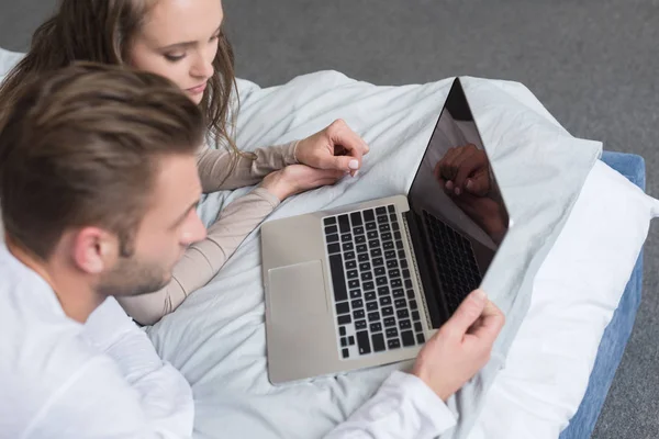 Pareja acostada con portátil — Foto de stock gratuita