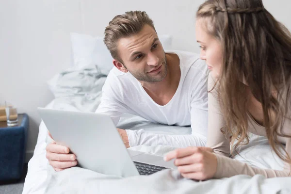 Paar liggen met laptop — Gratis stockfoto