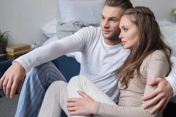 Couple sitting on floor in pajamas — Stock Photo, Image