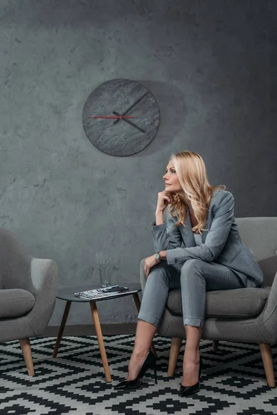 Business woman sitting on armchair in waiting room — стоковое фото