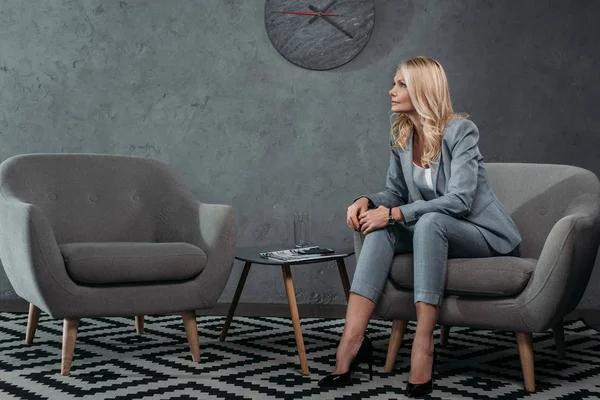 Businesswoman sitting on armchair in waiting room — Stock Photo, Image