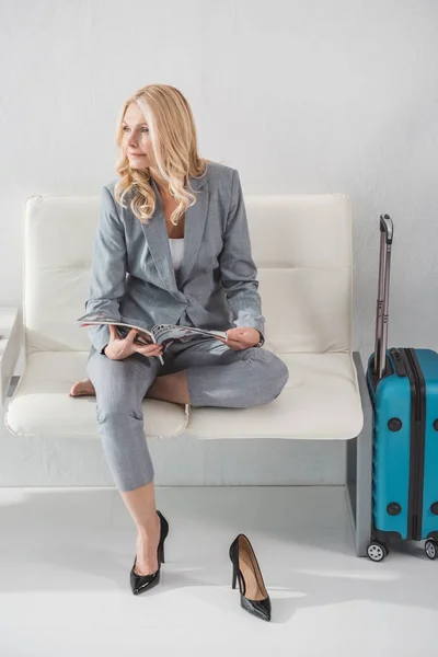 Geschäftsfrau mit Magazin wartet auf Reise — Stockfoto