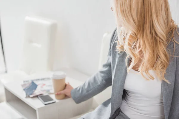 Businesswoman taking paper cup of coffee — Stock Photo, Image