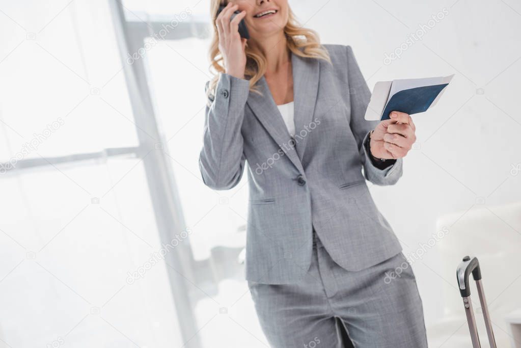 businesswoman with flight ticket talking by phone