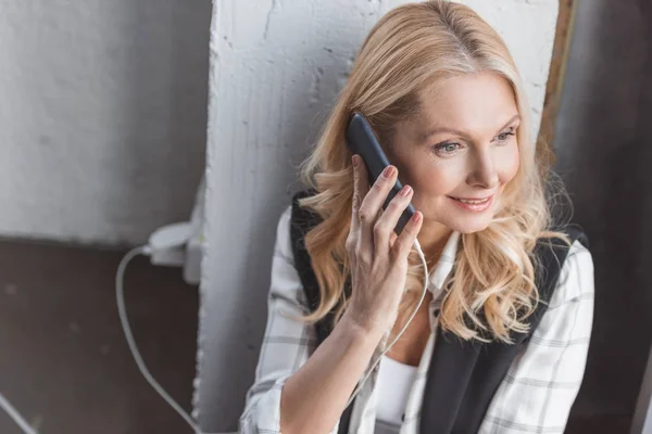 Businesswoman charging smartphone and making call — Stock Photo, Image