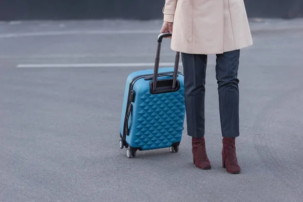 Woman in trench coat with suitcase — Stock Photo, Image