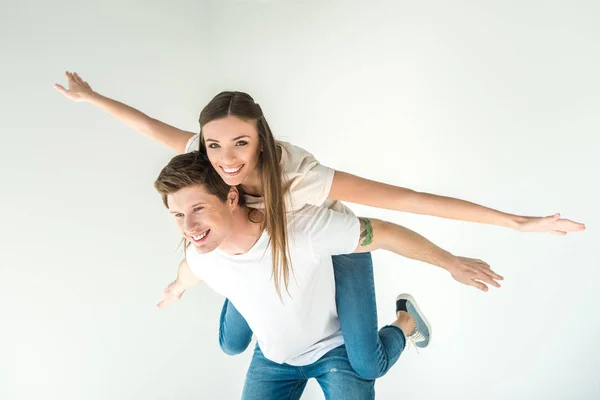 Feliz jovem casal piggybacking — Fotografia de Stock