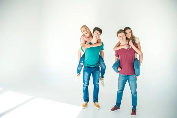 Feliz jóvenes amigos piggybacking — Foto de Stock