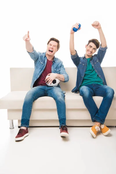Friends with soccer ball on sofa — Stock Photo, Image