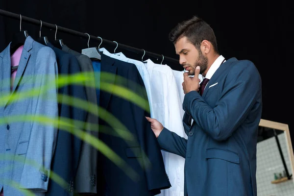 Бизнесмен выбирает костюм в бутике — стоковое фото