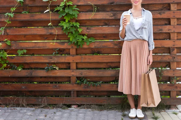 Girl with coffee to go and shopping bags — Stock Photo, Image