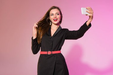 Kadın akıllı telefondan selfie çekiyor.