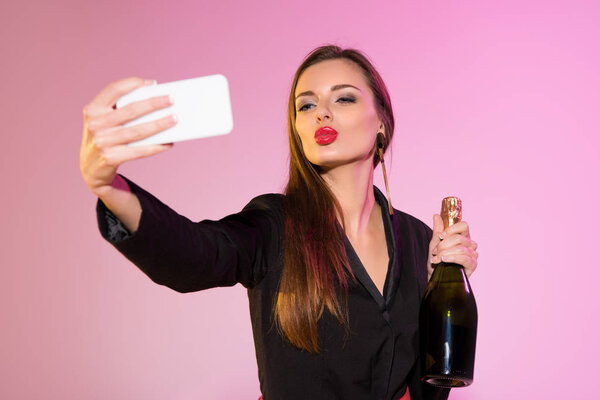 woman with champagne taking selfie