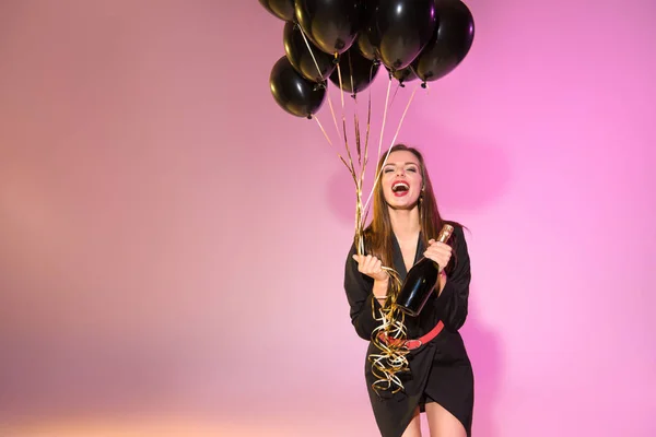 Excited woman with balloons and champagne — Stock Photo, Image