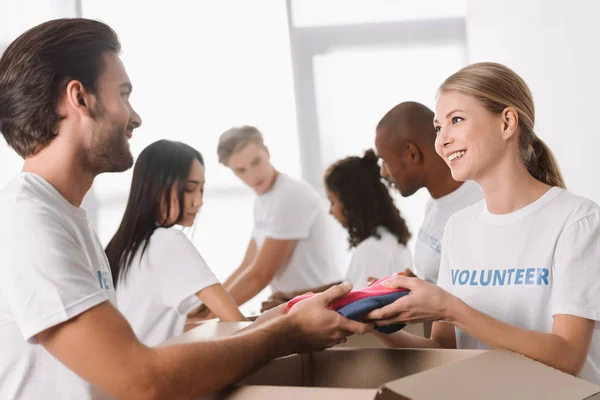 Voluntários que embalam roupas para caridade — Fotografia de Stock