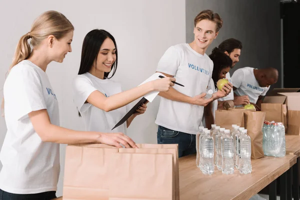 Voluntarios empacando comida para caridad — Foto de Stock