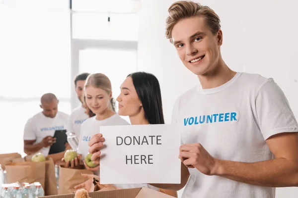 Voluntario sosteniendo cartel de caridad — Foto de Stock