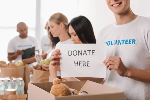 Voluntário segurando cartaz caridade — Fotografia de Stock