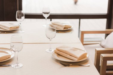 Served table with wineglasses and plates with napkins clipart