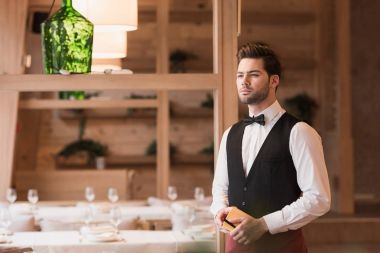 Waiter standing with notebook and pen clipart