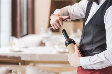 waiter opening bottle of wine