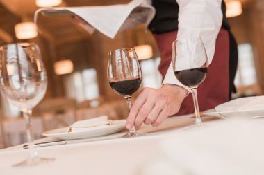 waiter serving wineglasses on table clipart