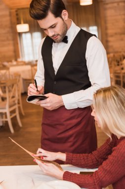 Waiter writing down the order of customer clipart