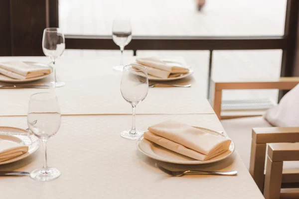 Mesa servida con gafas de vino y platos con servilletas — Foto de Stock