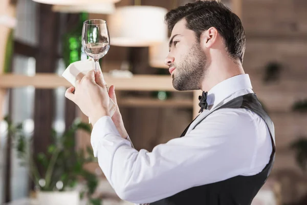 Waiter looking at clean wineglass — Stock Photo, Image