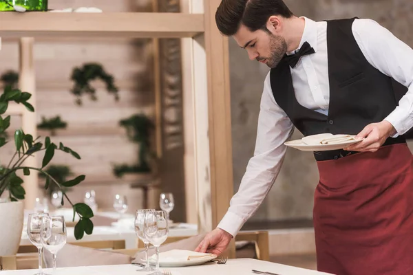 Waiter serving plates on table — Stock Photo, Image