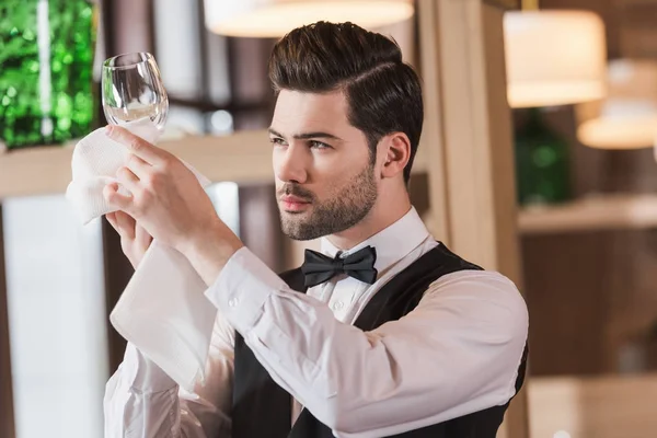 Waiter looking at clean wineglass — Stock Photo, Image